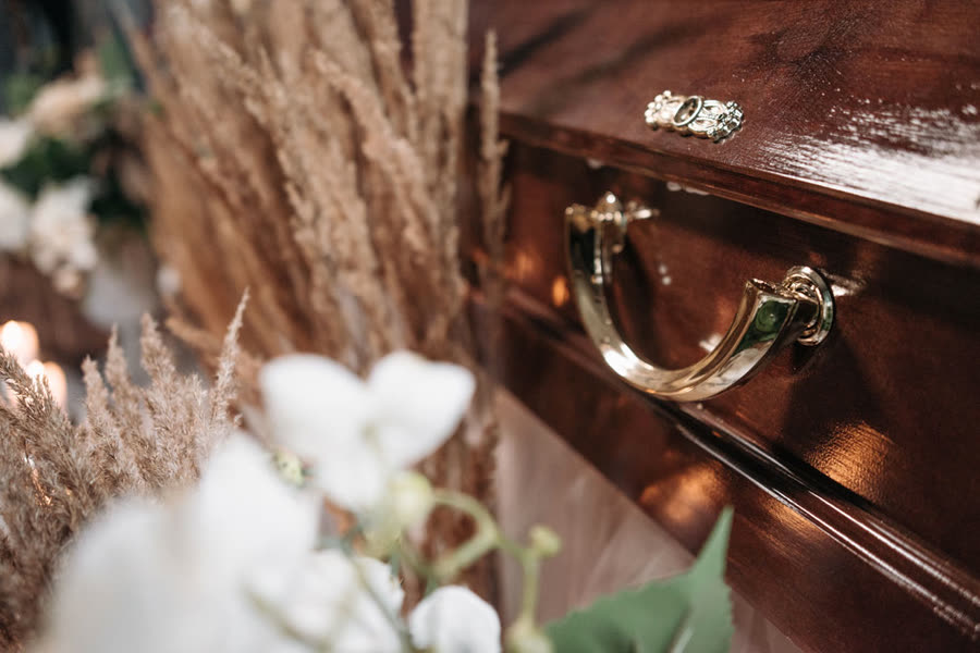 Witte bloemen en droogbloemen bij een houten kist
